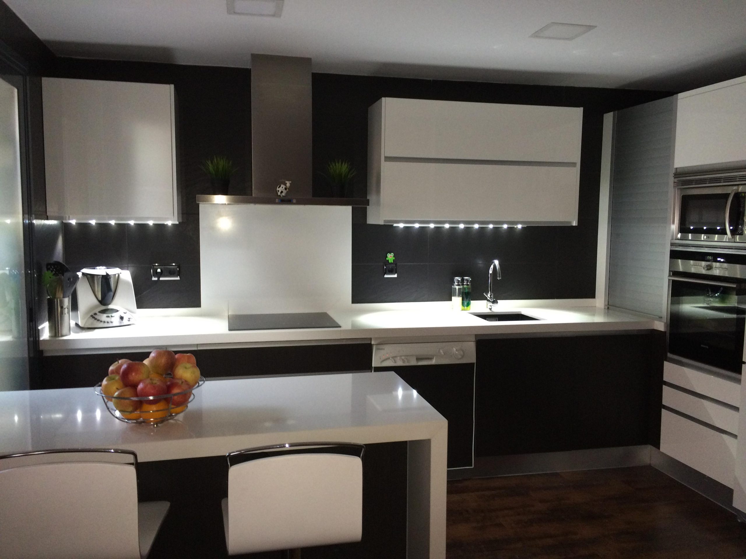 Cocina reformada con iluminación LED y muebles en tono oscuro